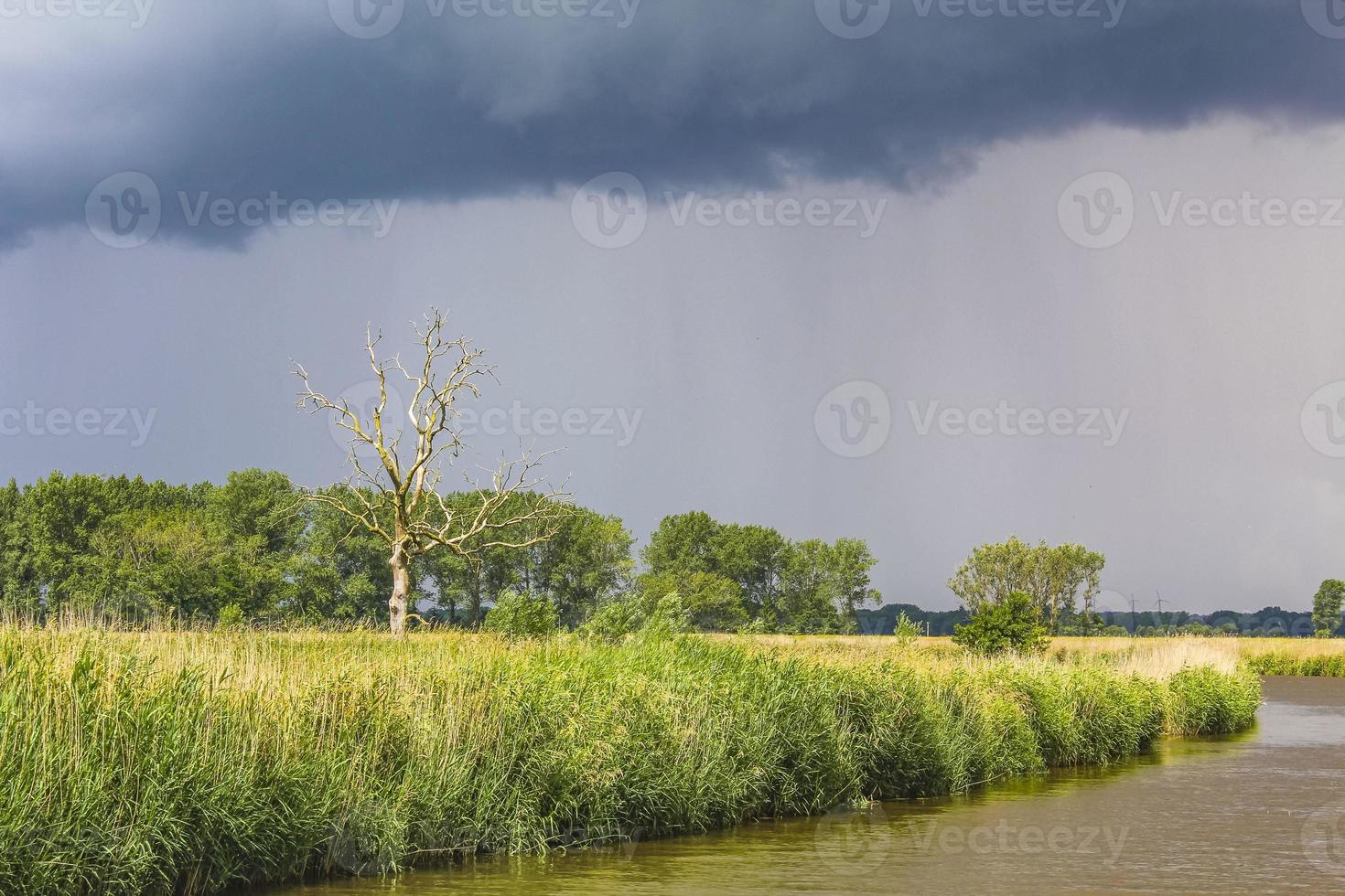 Heavy rain storm clouds wind waves water Oste river Germany. photo