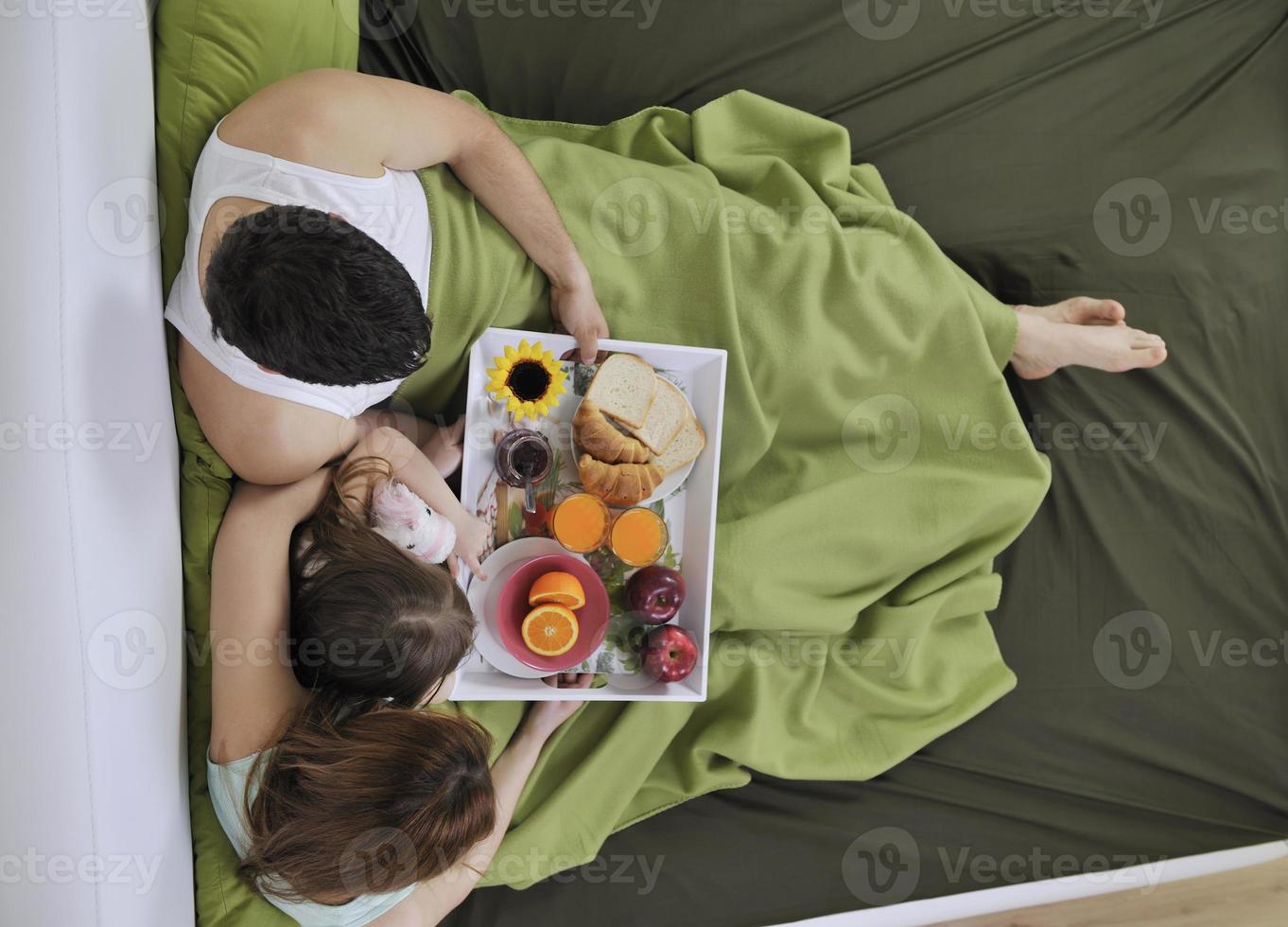 happy young family eat breakfast in bed photo