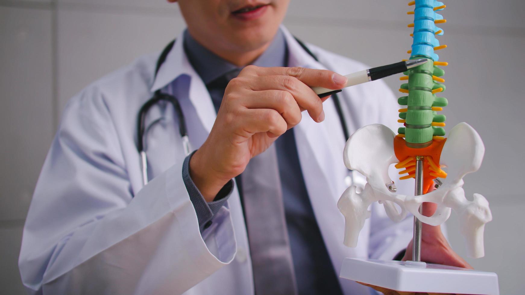 A male doctor explains the physiology of the human body via video call conference. photo