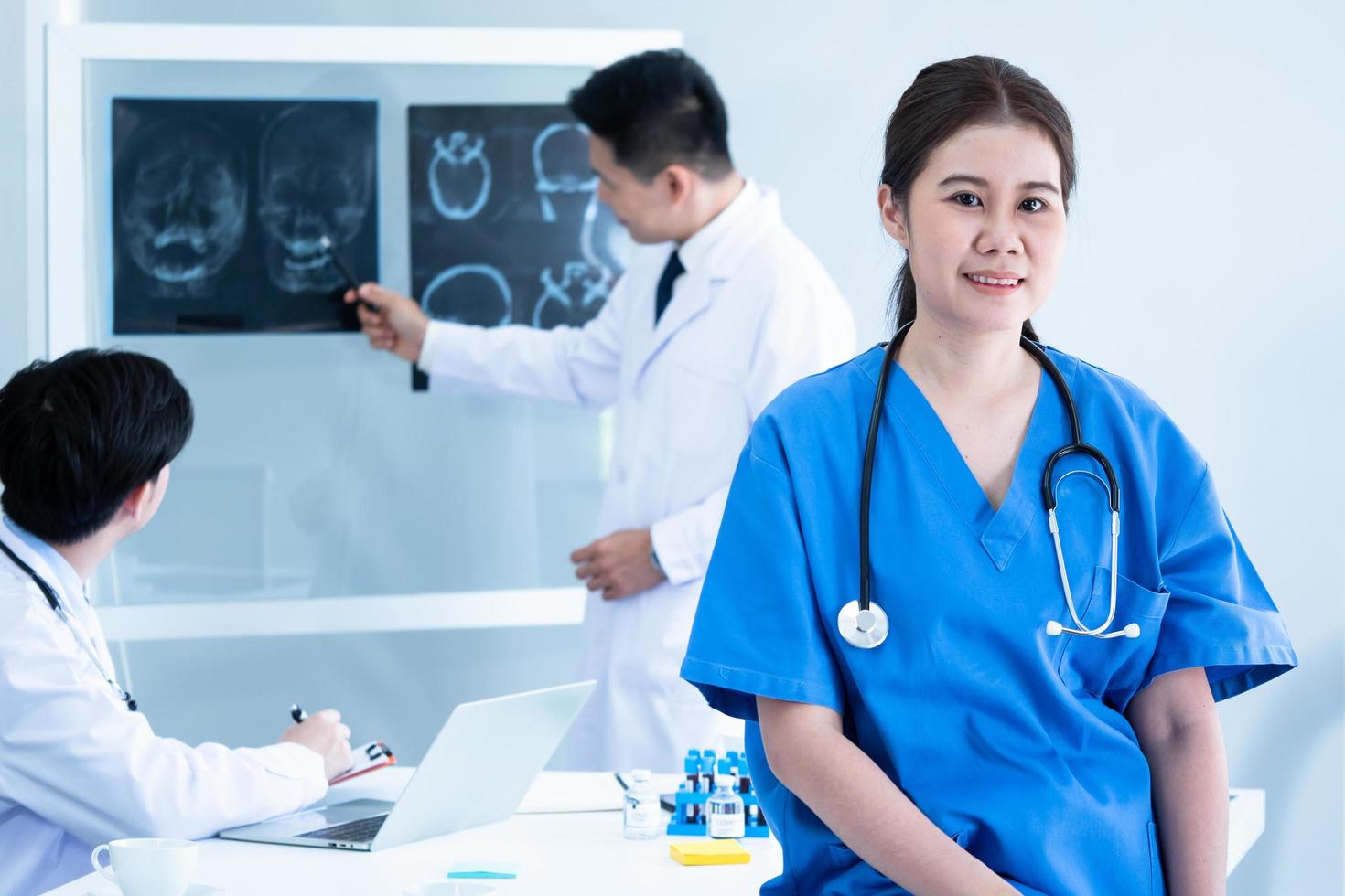 Doctor and medical assistants discussing about diagnosis result on x-ray film. photo