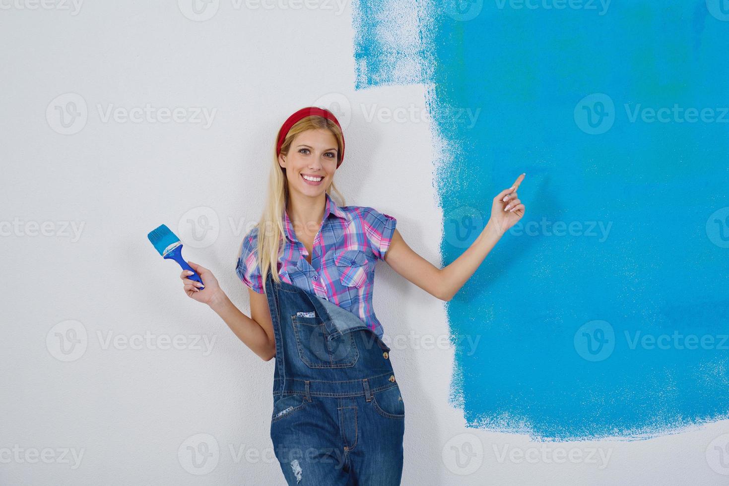 happy smiling woman painting interior of house photo