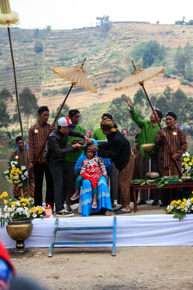 Dieng, Indonesia - August 1, 2015. Dieng Culture Festival, Tourists follow the dreadlocks procession during the Dieng Culture Festival event at Dieng, Banjarnegara district, Central Java photo