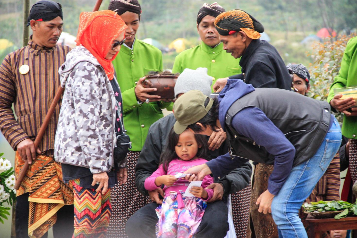 dieng, indonesia - 1 de agosto de 2015. festival cultural de dieng, los turistas siguen la procesión de rastas durante el evento del festival cultural de dieng en dieng, distrito de banjarnegara, java central foto