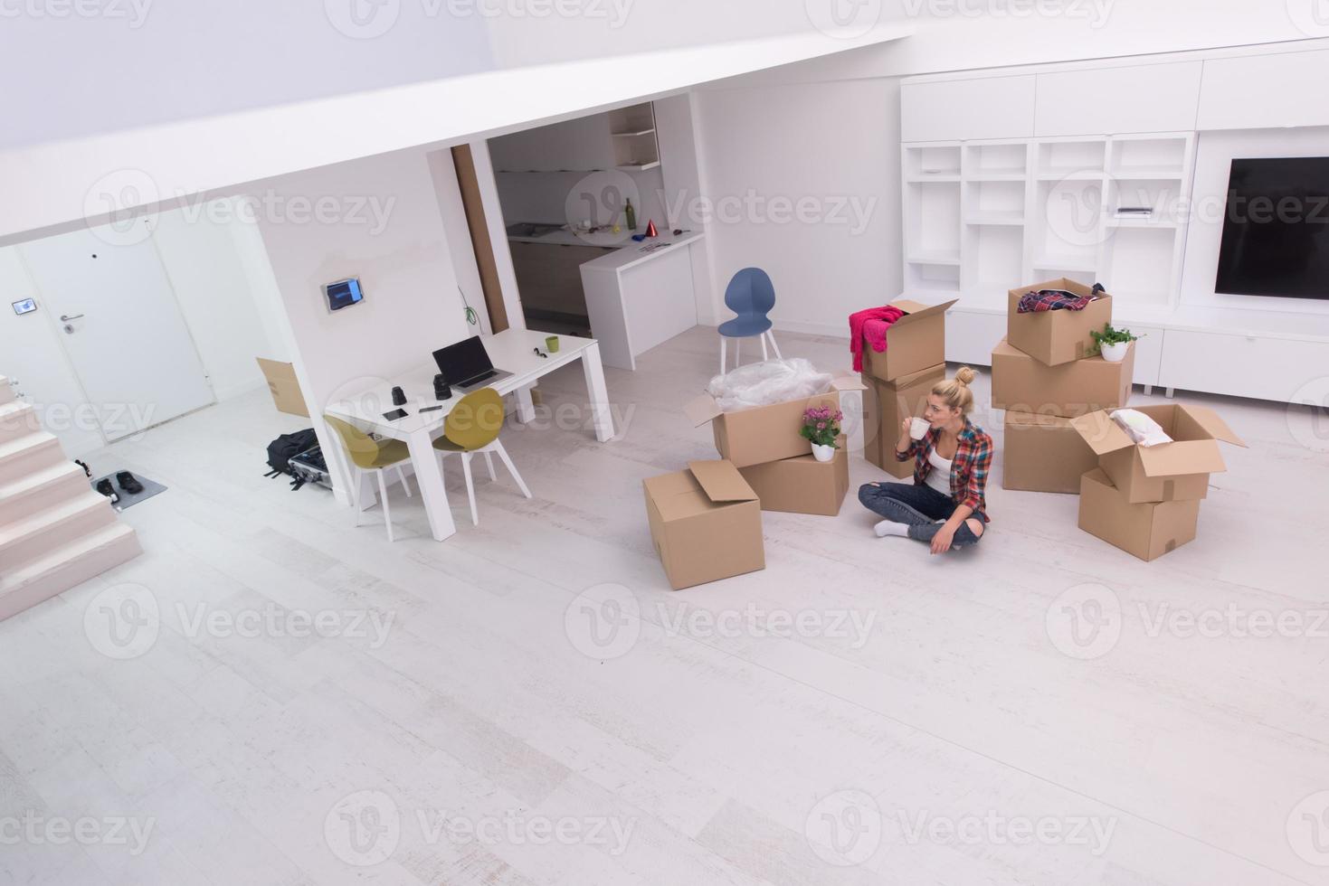 woman with many cardboard boxes sitting on floor photo