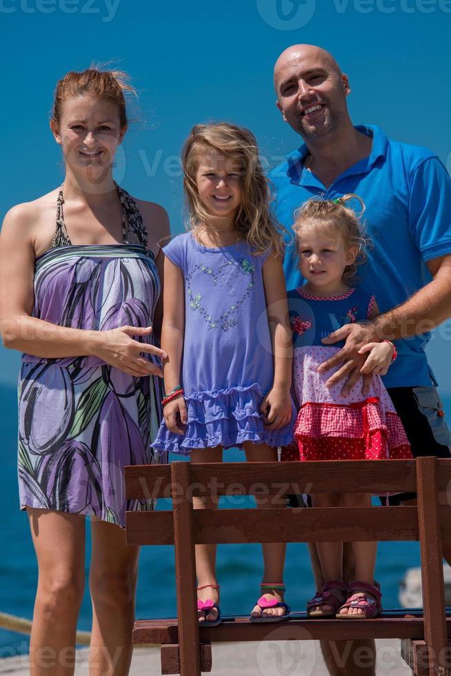 retrato de una joven familia feliz con hijas junto al mar foto