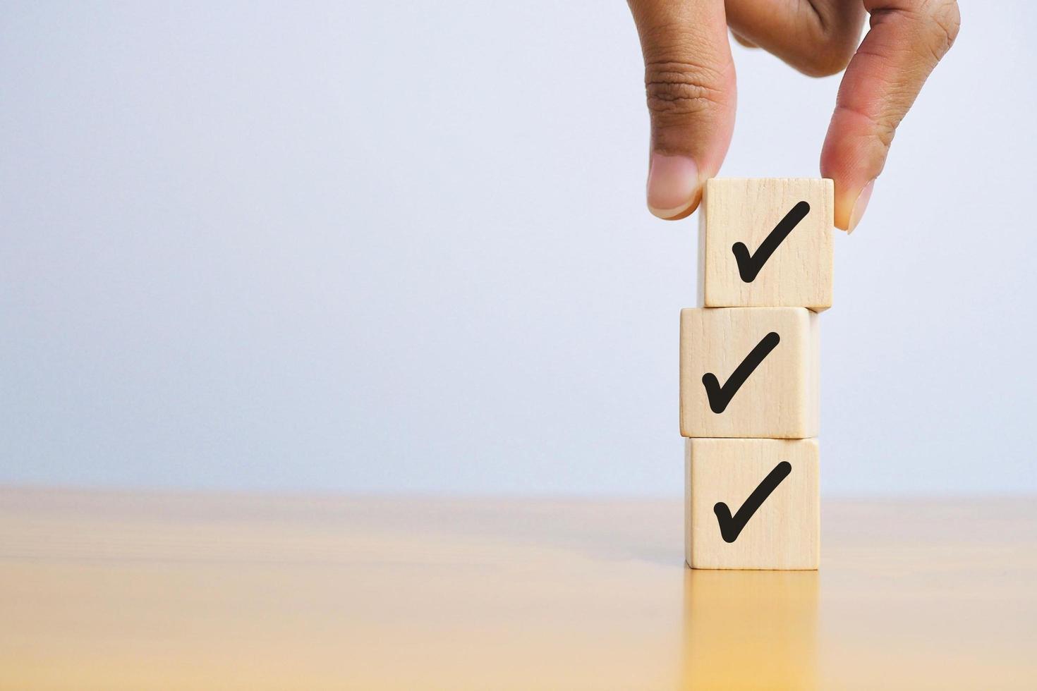 checklist concept check mark on wooden block on wooden floor with copy space photo