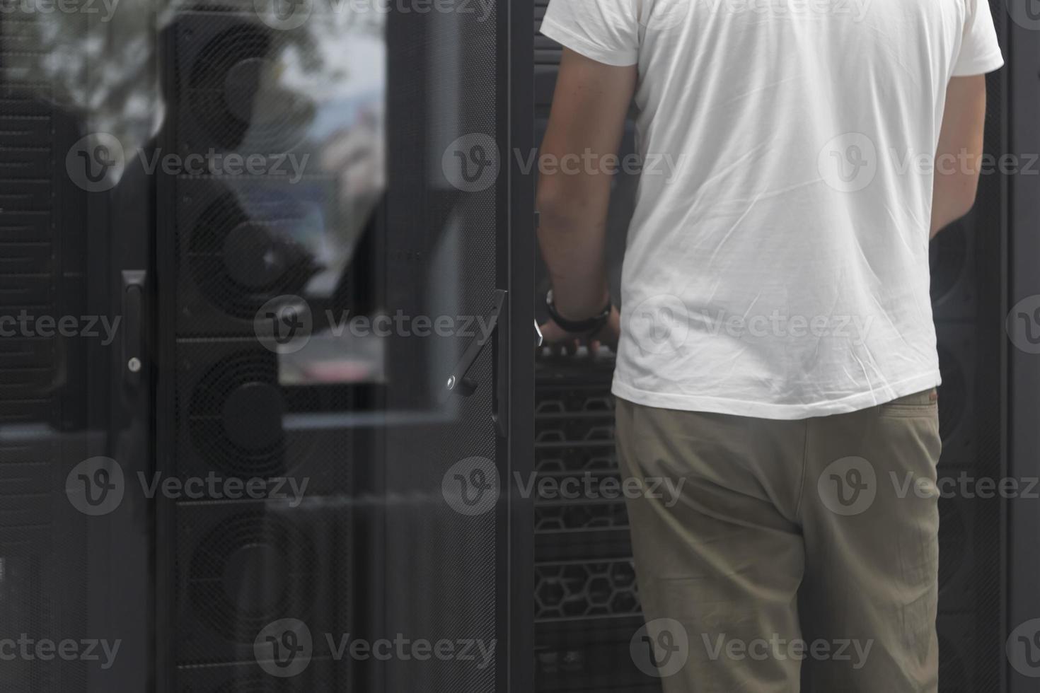 ingeniero de centro de datos usando computadora portátil. instalación especializada en la sala de servidores con un administrador de sistemas masculino coreano que trabaja con una red de protección de datos para la seguridad cibernética. foto