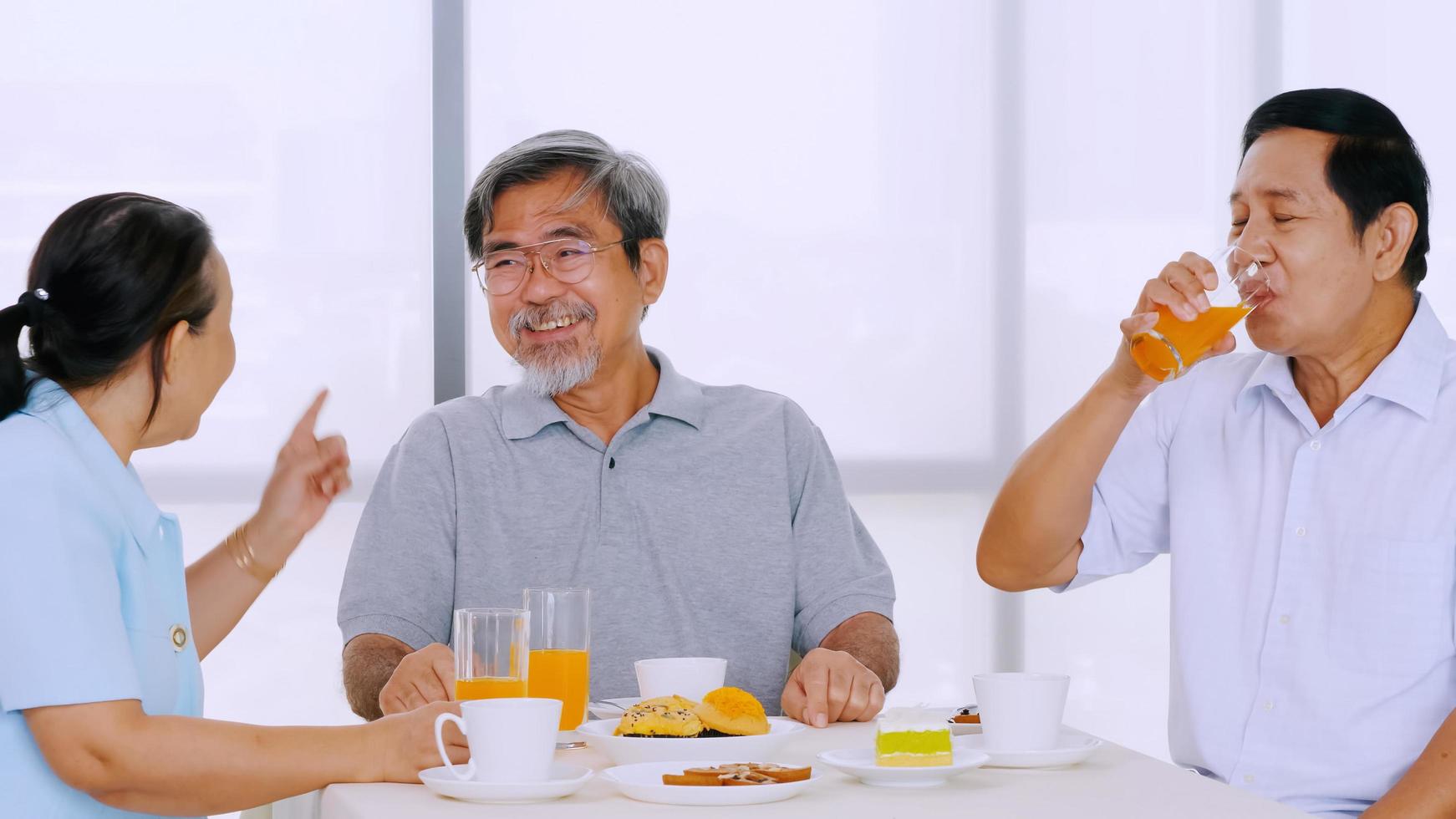 Group of senior friends enjoying eating on dining table photo