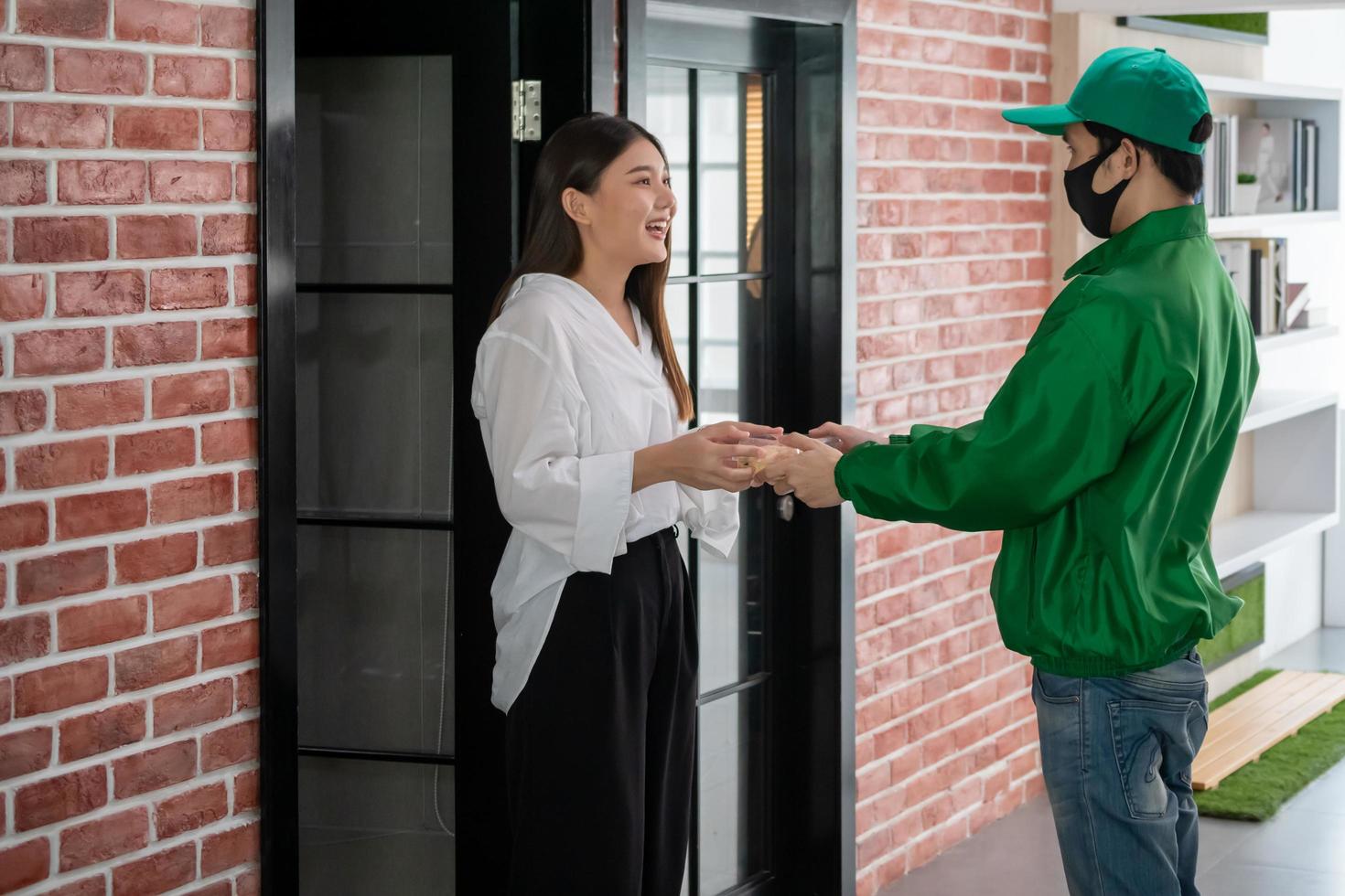 Happy woman recieving food from food deliveryman photo