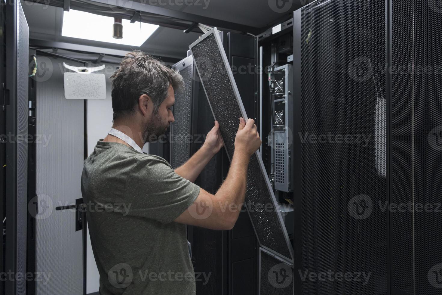 IT engineer working In the server room or data center The technician puts in a rack a new server of corporate business mainframe supercomputer or cryptocurrency mining farm. photo