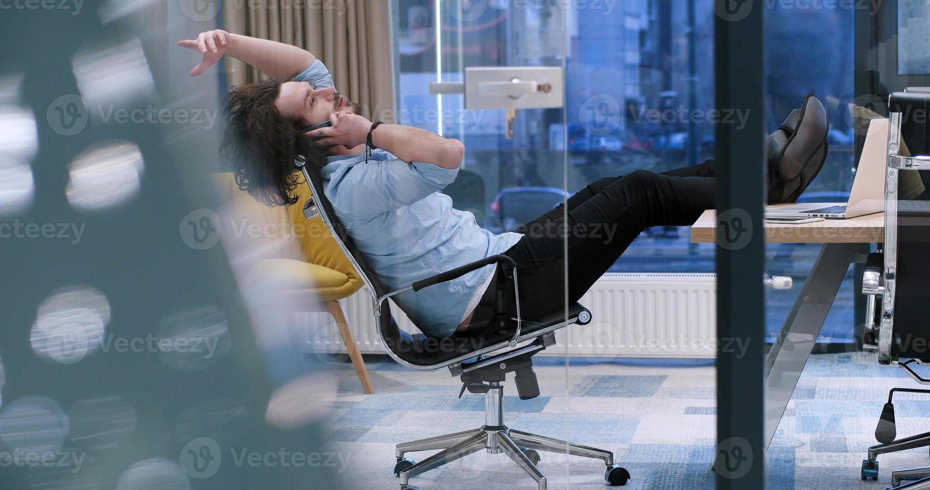 businessman sitting with legs on desk photo