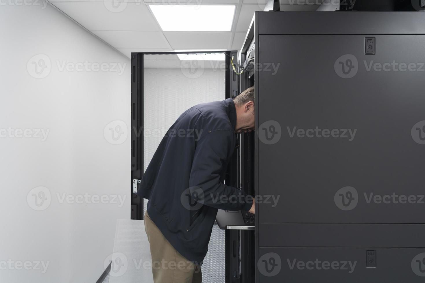 Technicians team updating hardware inspecting system performance in super computer server room or cryptocurrency mining farm. photo