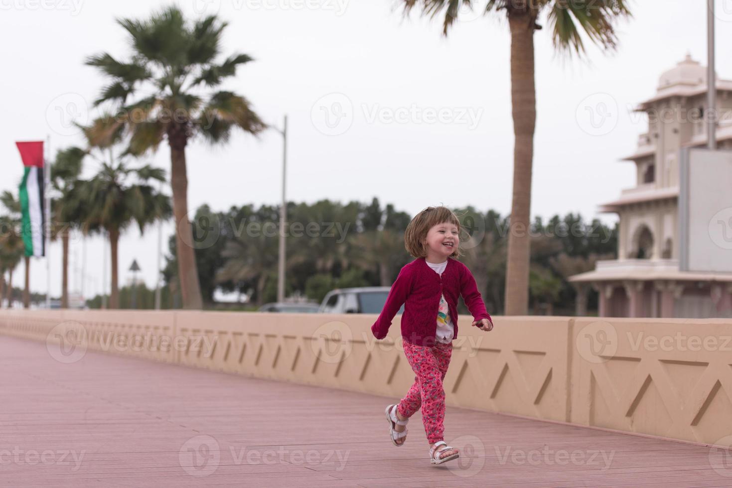 cute little girl on the promenade by the sea photo