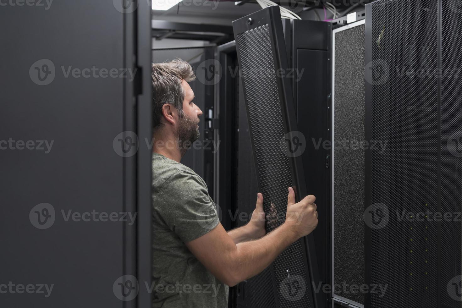 IT engineer working In the server room or data center The technician puts in a rack a new server of corporate business mainframe supercomputer or cryptocurrency mining farm. photo