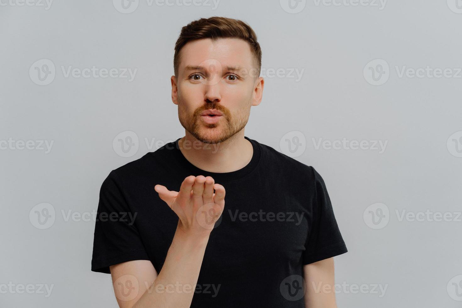 Young guy blowing air kiss to his girlfriend and demonstrating feelings photo