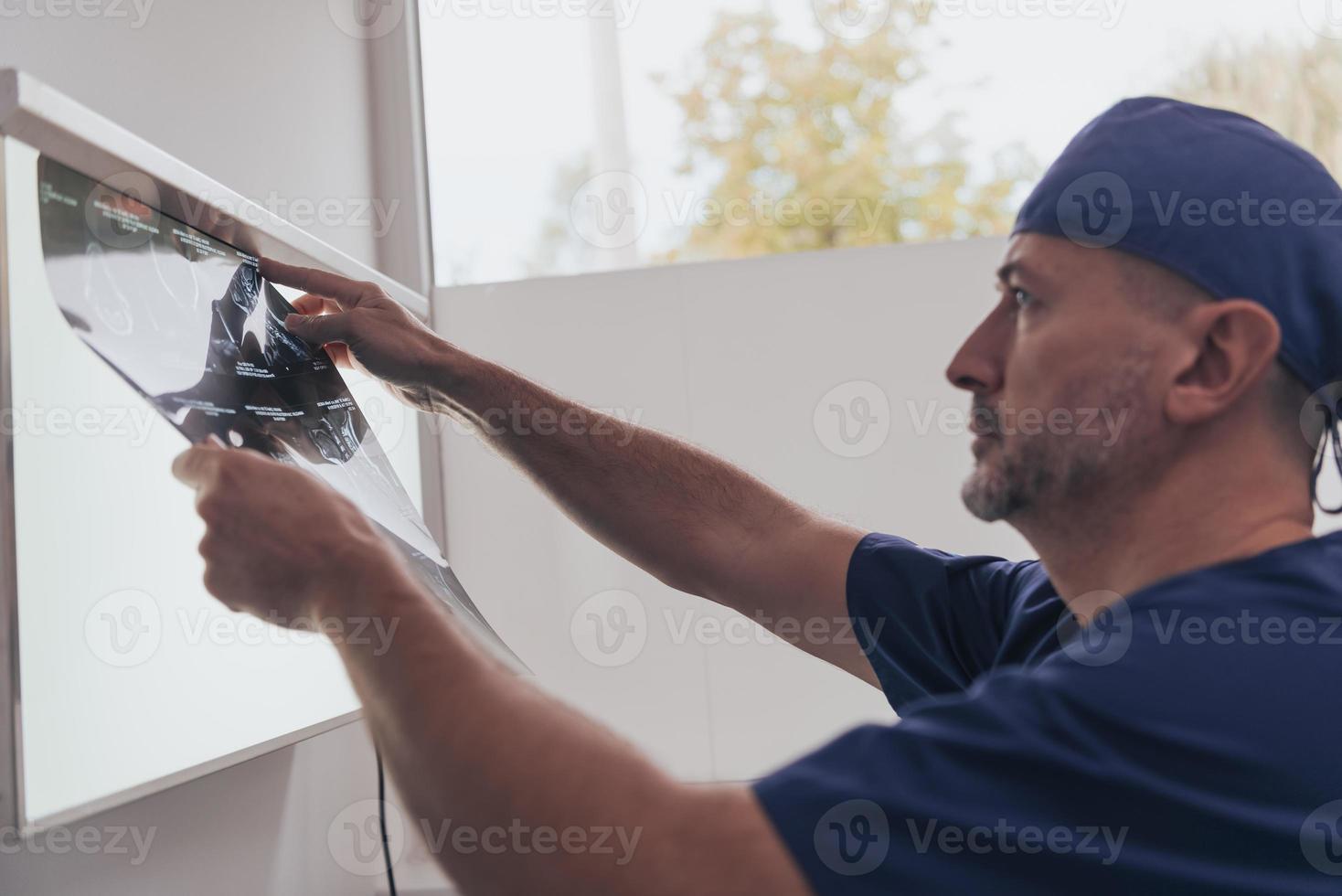 Orthopedist doctor examining X-ray picture in hospital or clinic photo