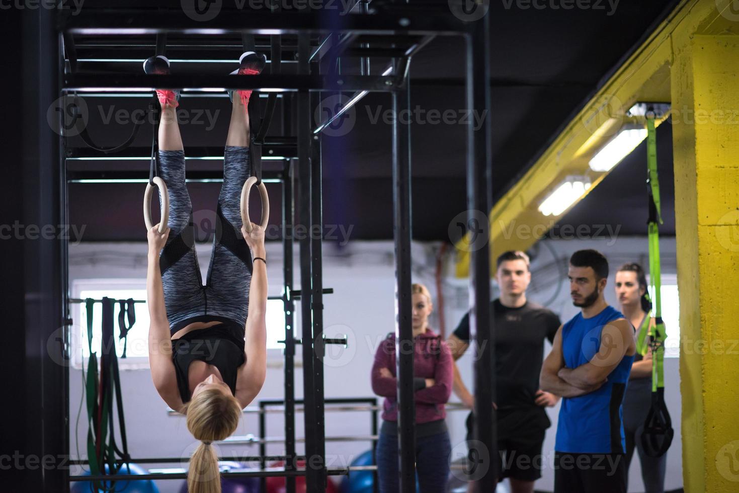 woman working out with personal trainer on gymnastic rings photo