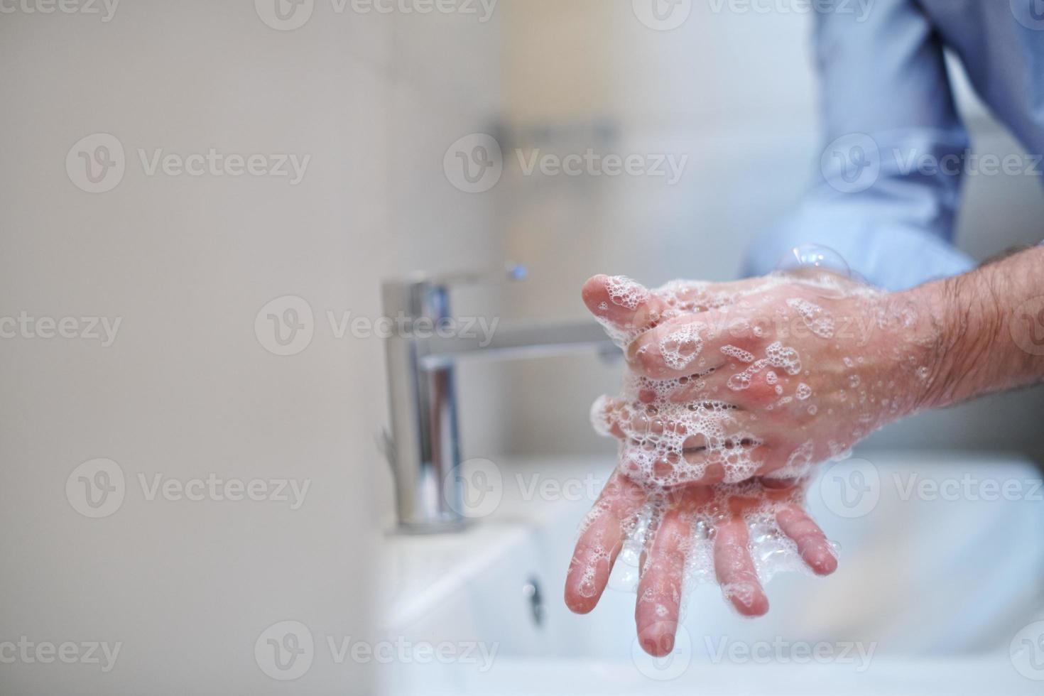 coronavirus masculino lavándose las manos en el baño foto