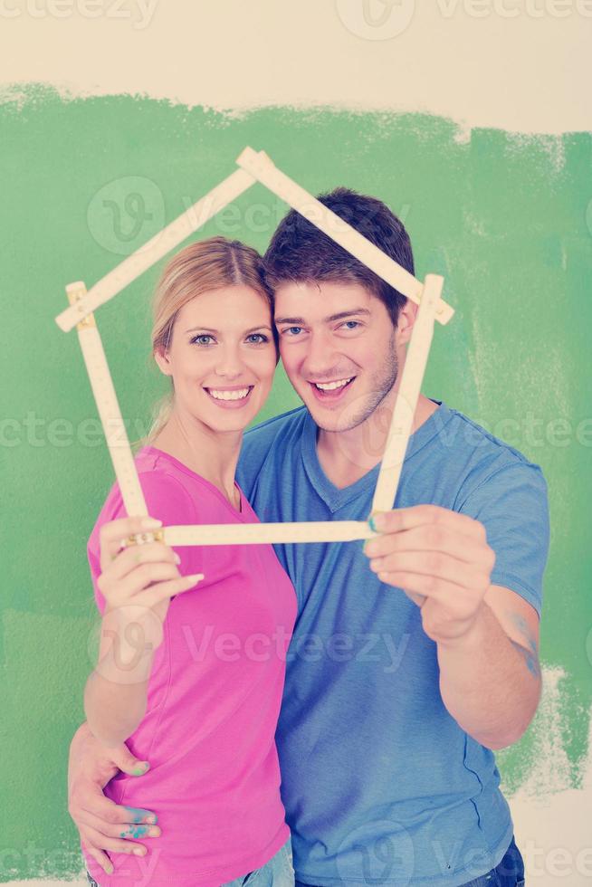 pareja feliz pintando una pared en su nuevo hogar foto