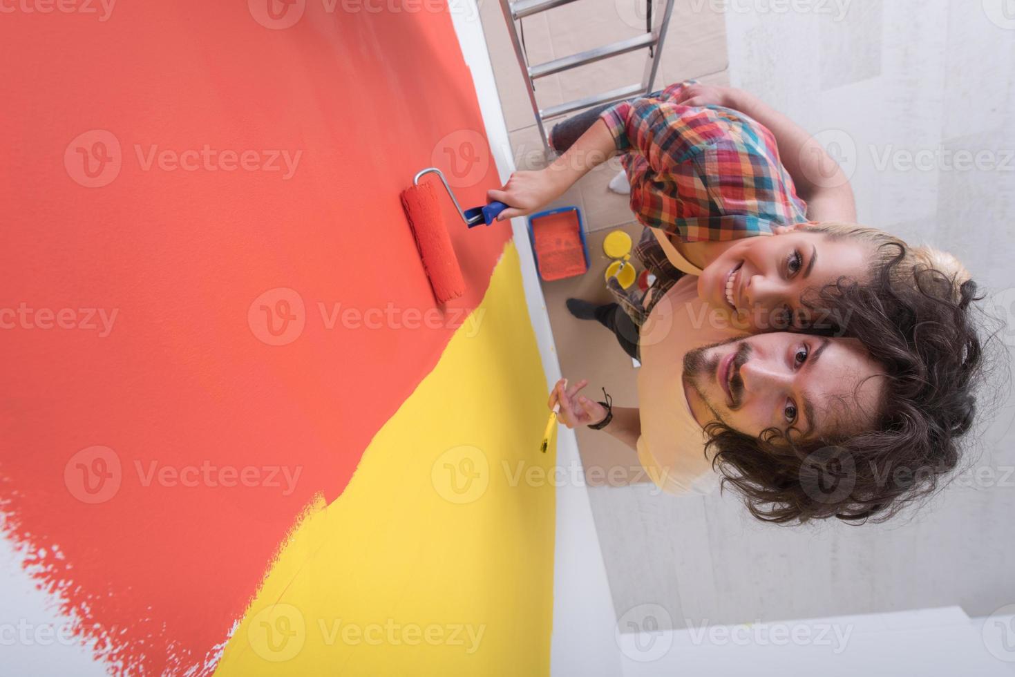 couple painting interior wall photo