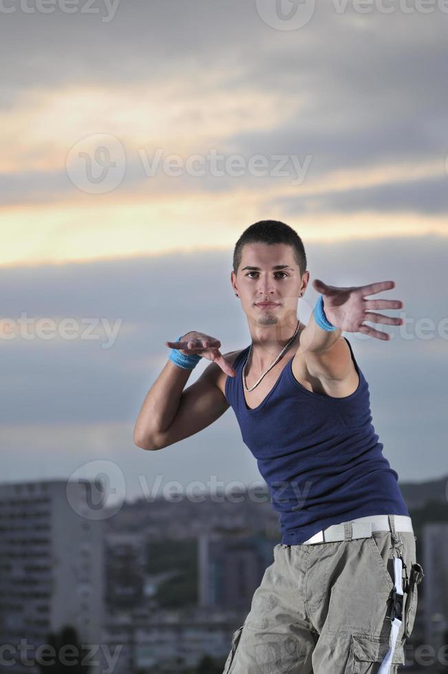 young man dancing and jumping  on top of the building photo