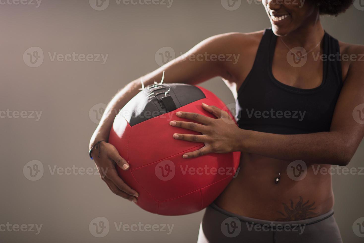 black woman carrying crossfit ball photo