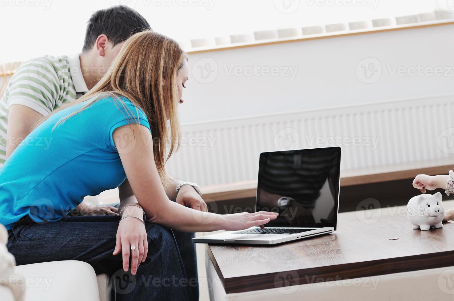 young couple working on laptop at home photo
