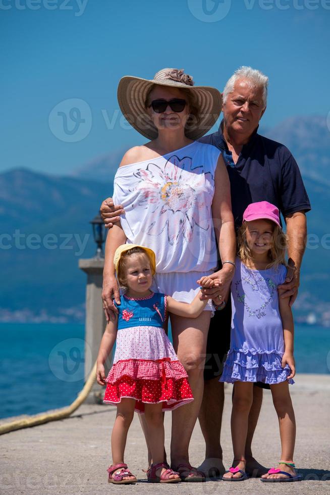 portrait of grandparents and granddaughters standing by the sea photo