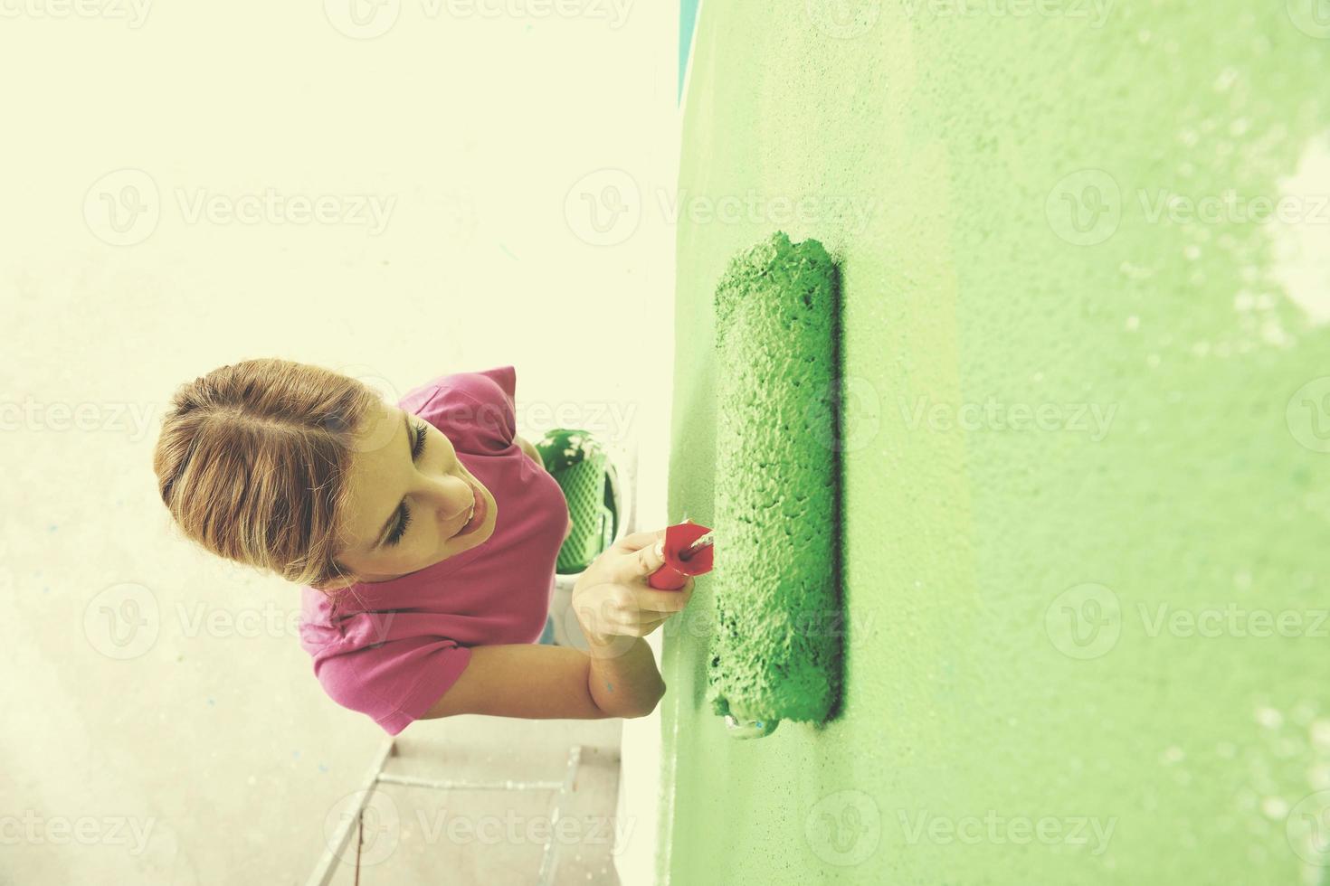happy smiling woman painting interior of house photo
