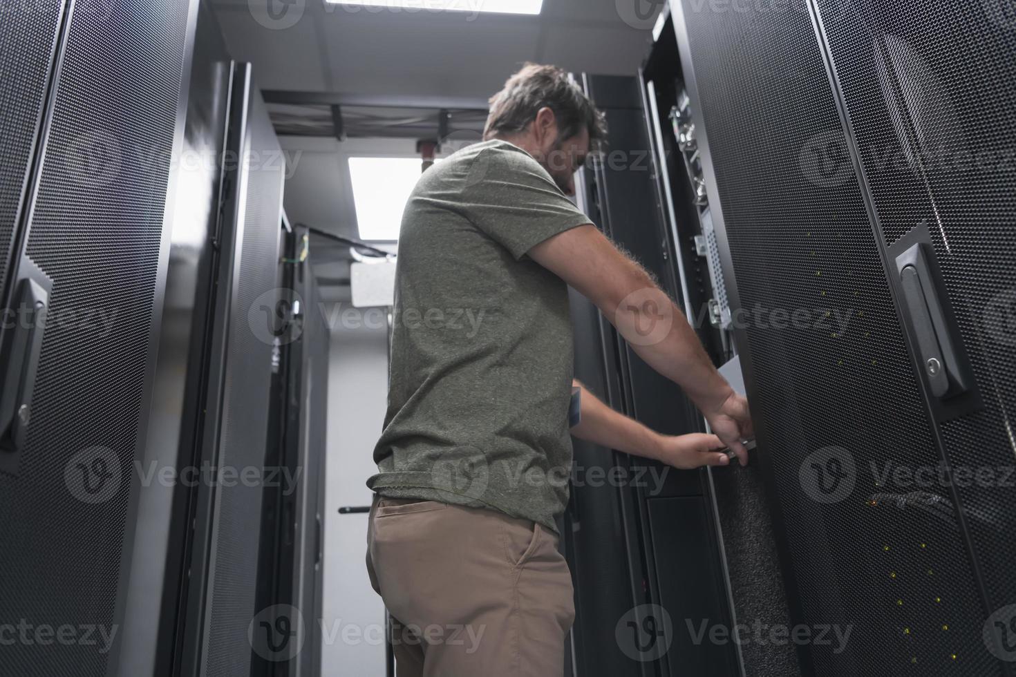 IT engineer working In the server room or data center The technician puts in a rack a new server of corporate business mainframe supercomputer or cryptocurrency mining farm. photo