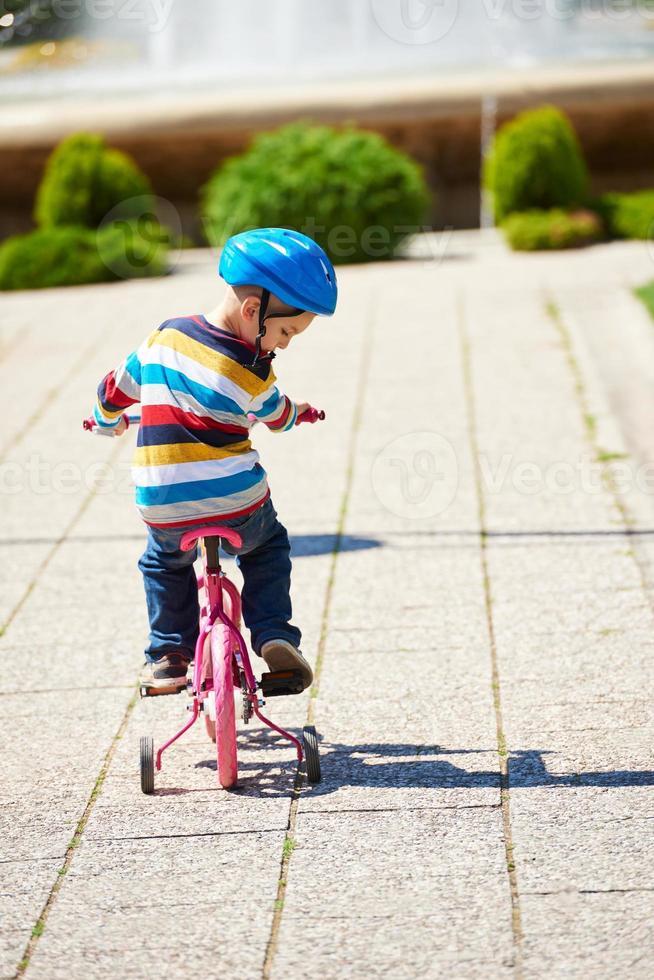 happy boy learning to ride his first bike photo