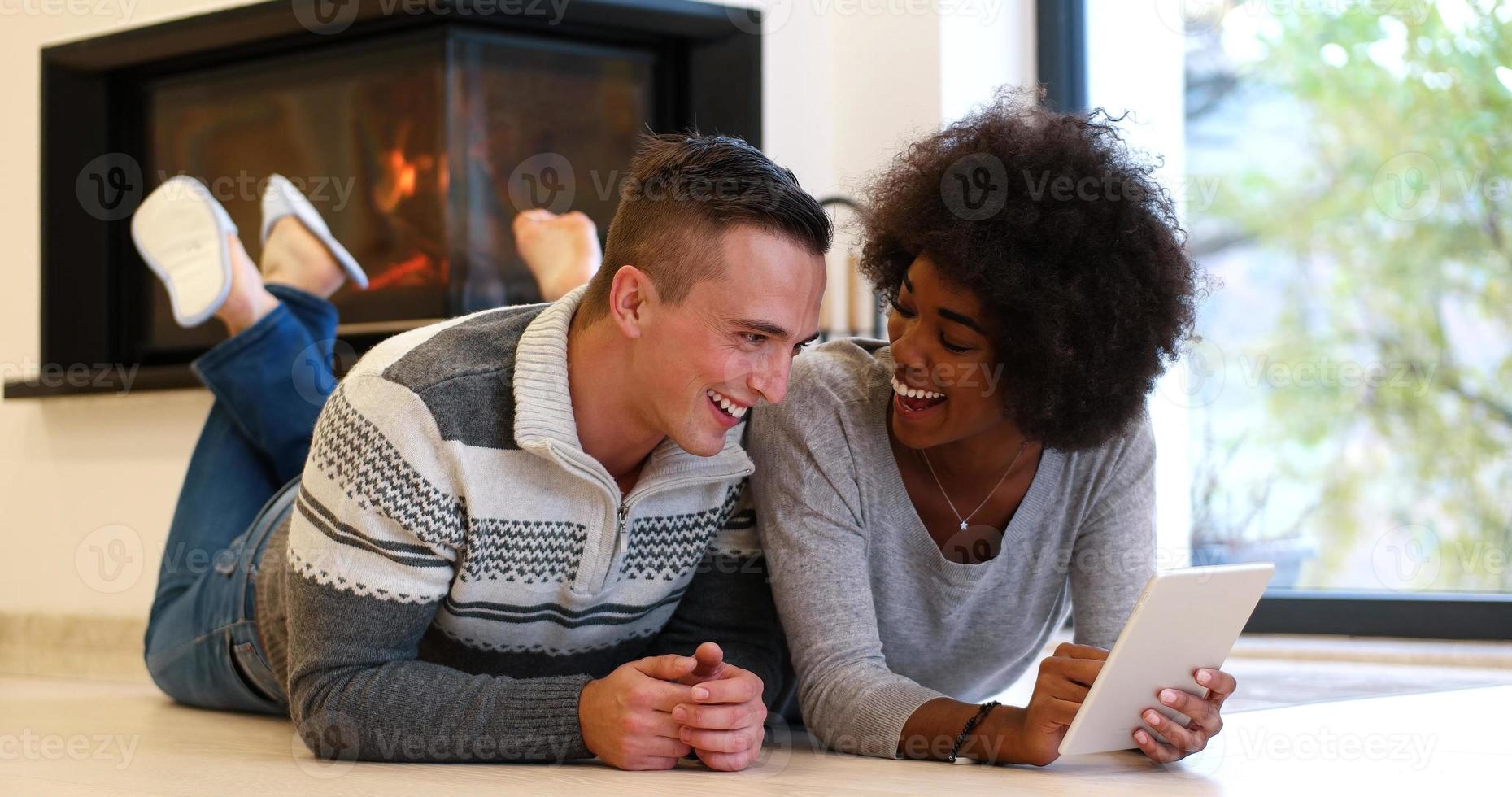 multiethnic couple using tablet computer on the floor photo