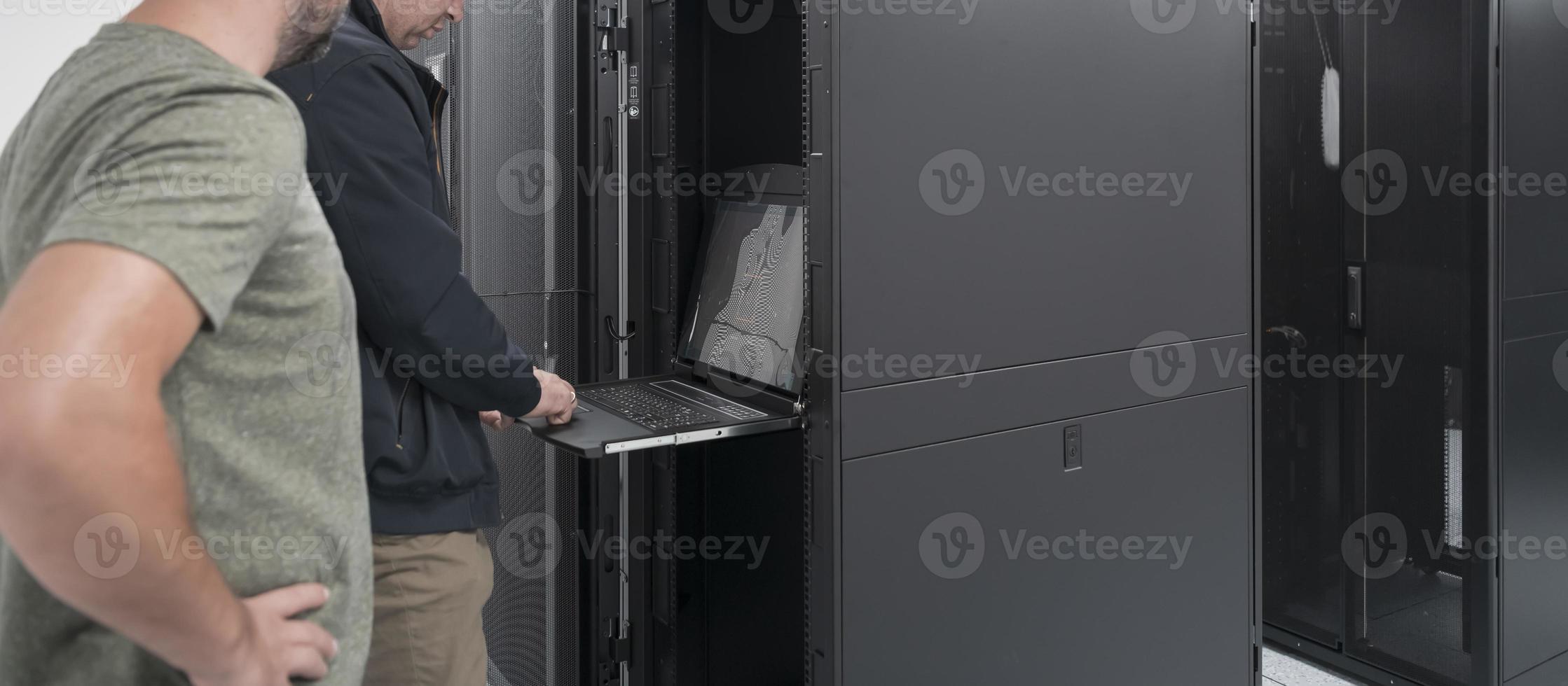 Technicians team updating hardware inspecting system performance in super computer server room or cryptocurrency mining farm. photo