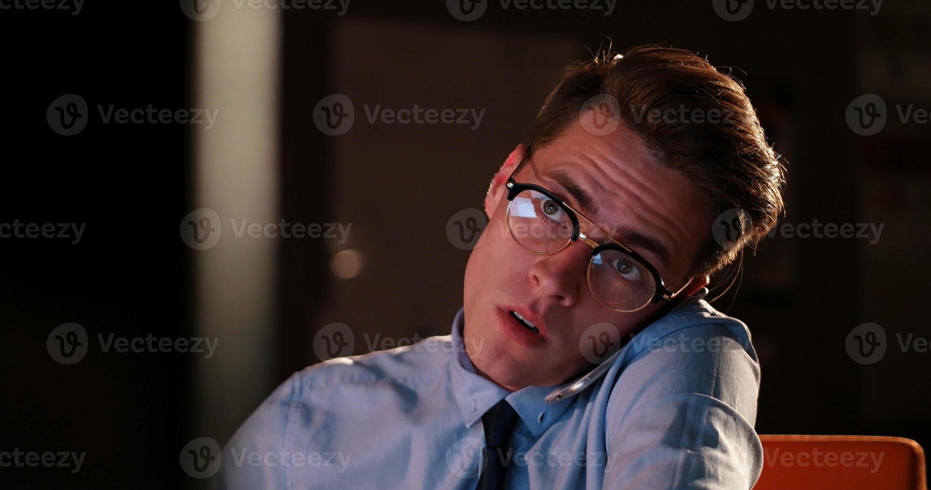 man using mobile phone in dark office photo