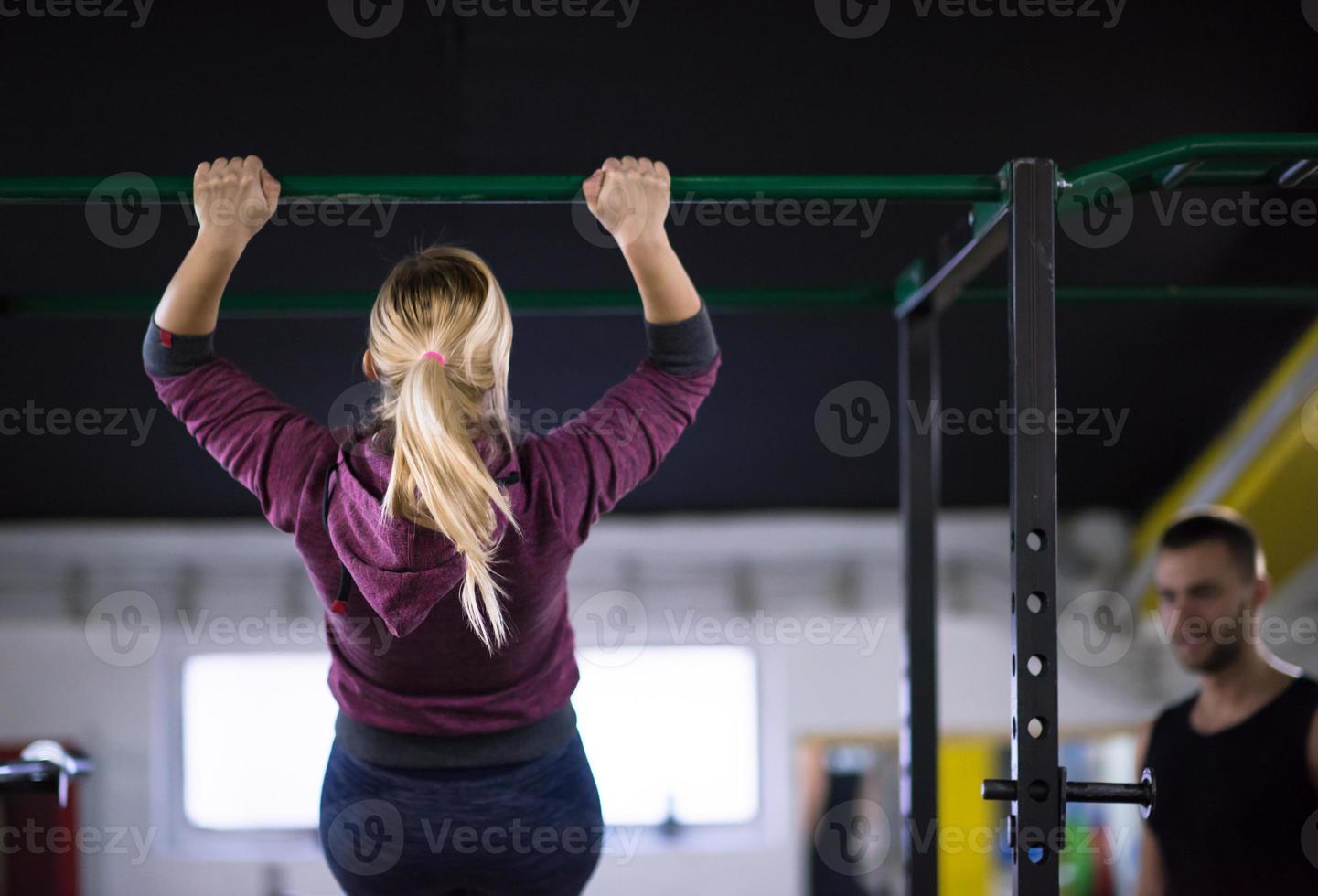 woman doing pull ups on the horizontal bar photo