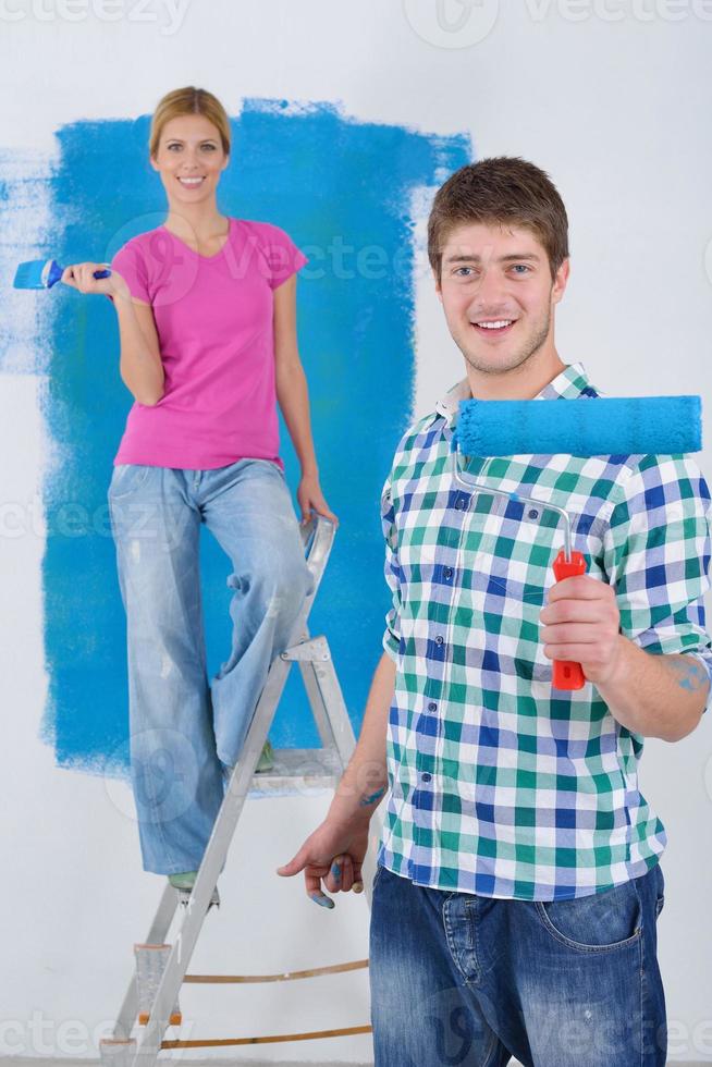 happy couple paint wall at new home photo