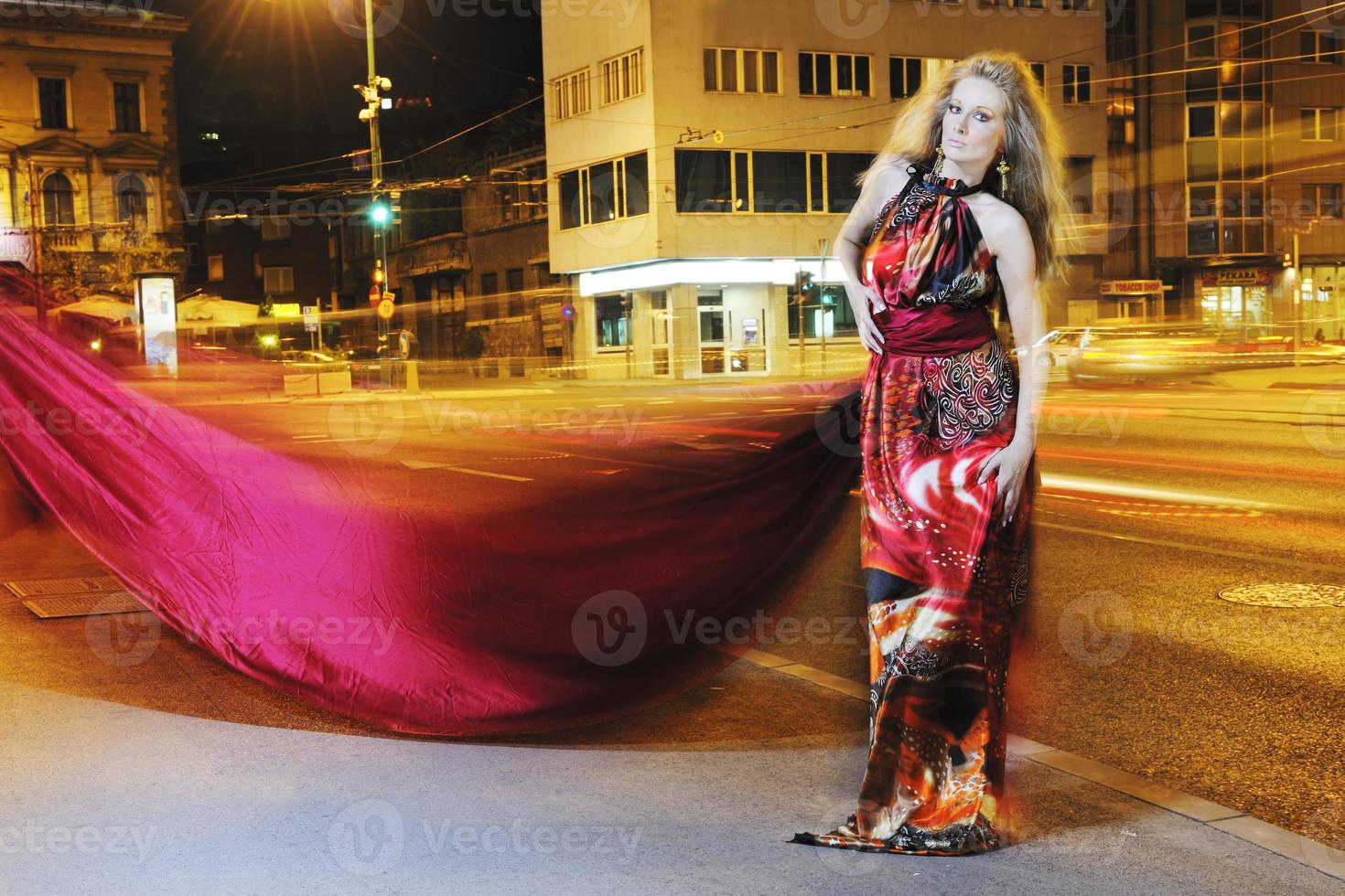 elegant woman on city street at night photo