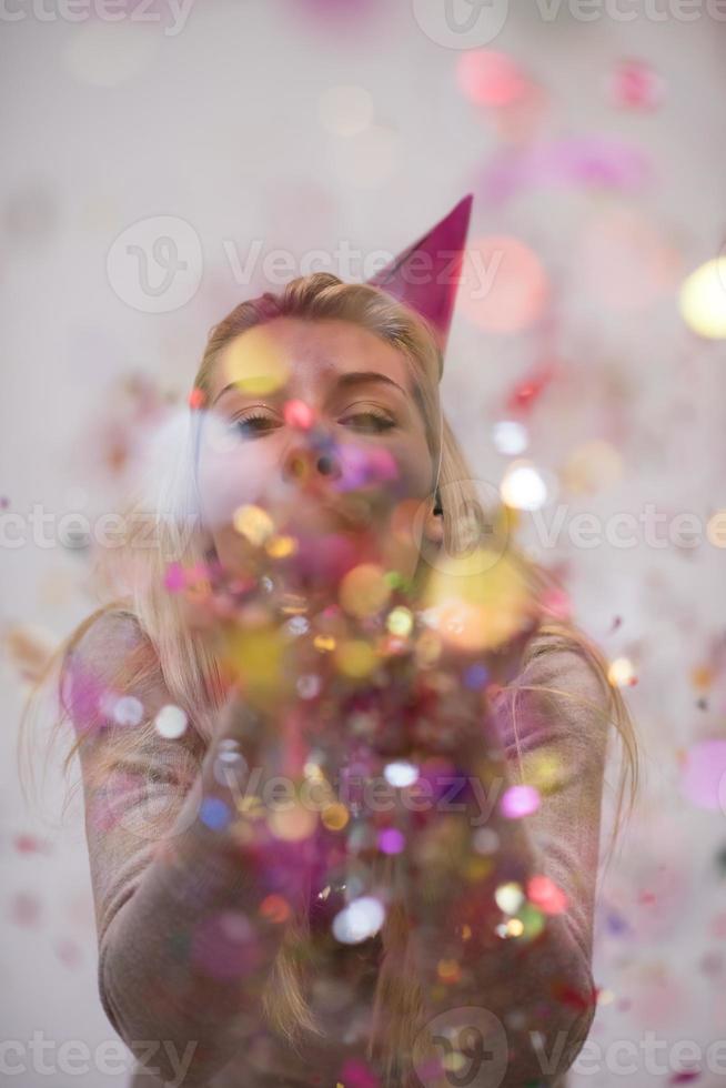 mujer soplando confeti en el aire foto