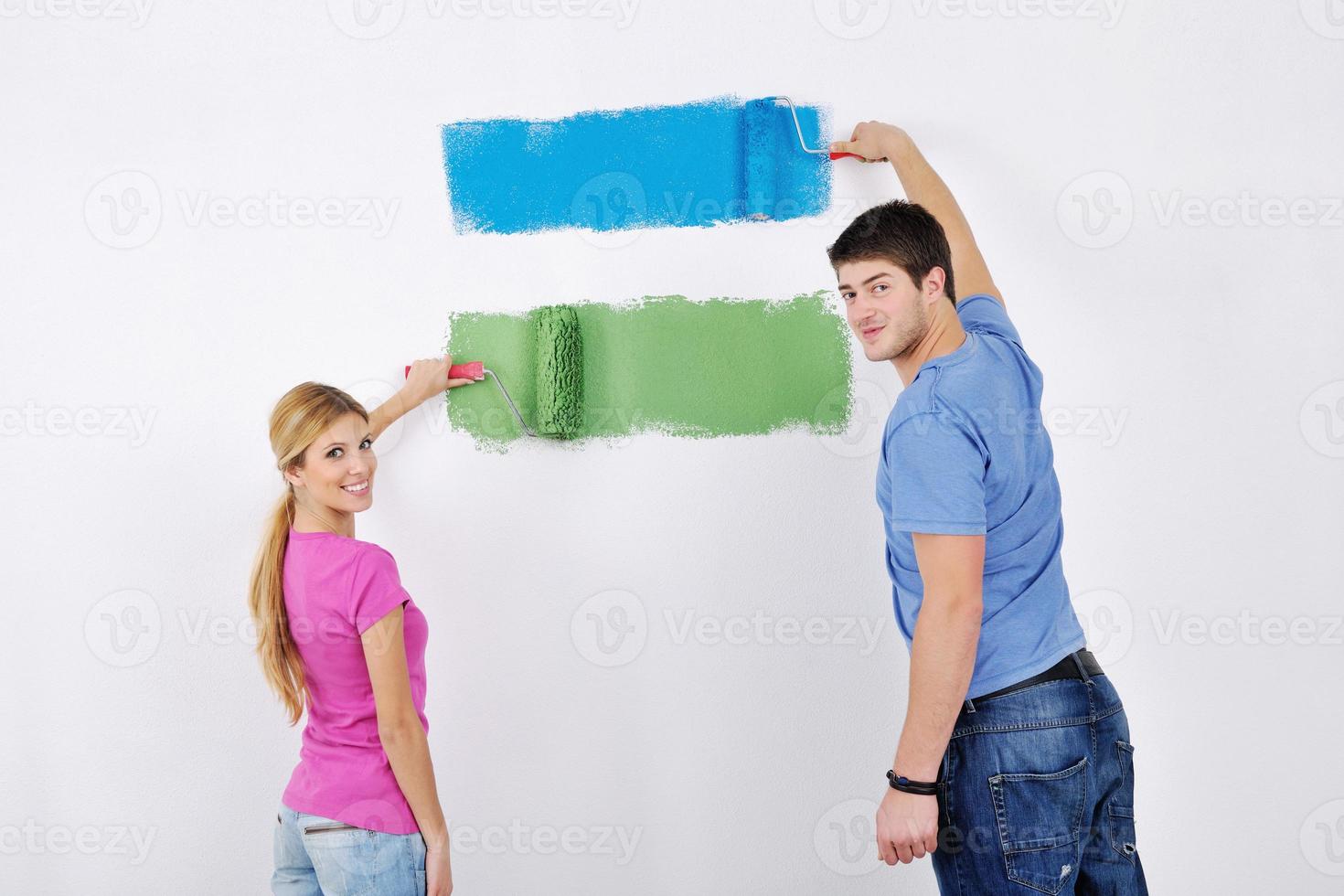 happy couple paint wall at new home photo