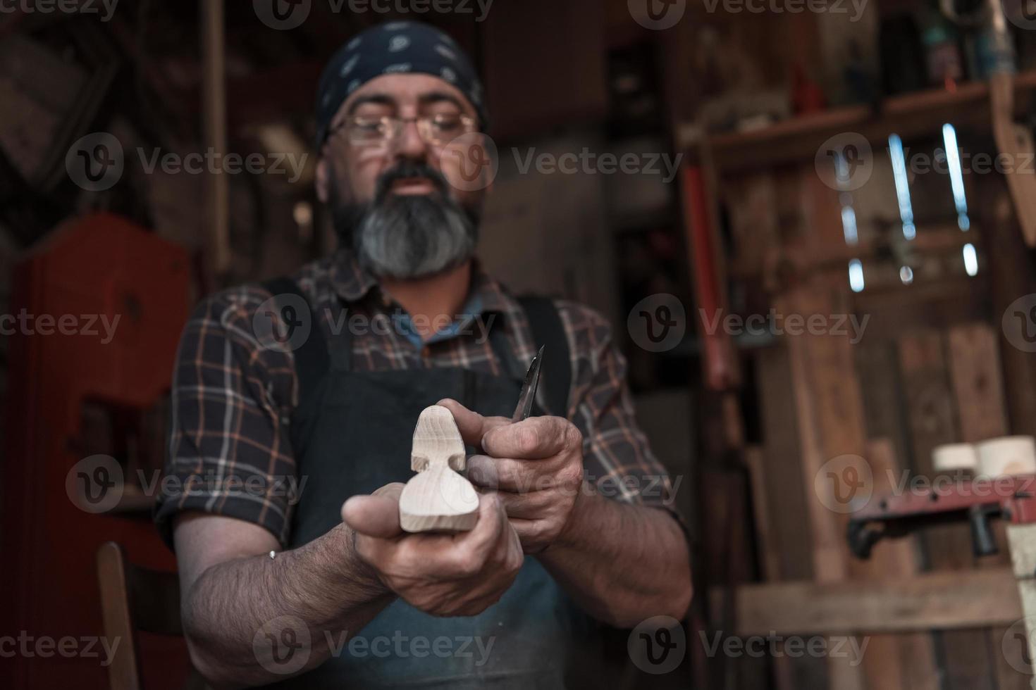 Spoon craft master in his workshop with handmade wooden products and tools working photo