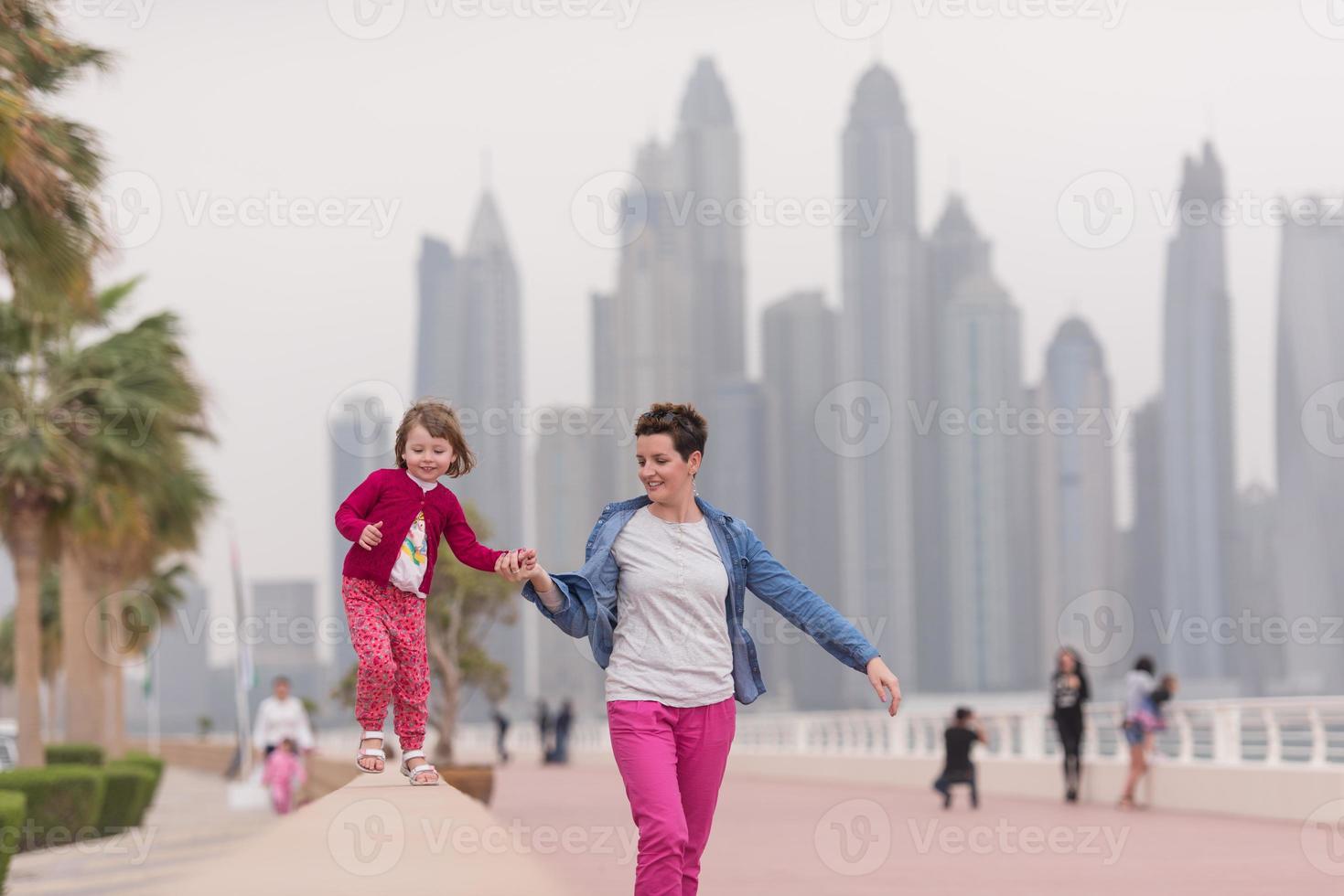 madre y niña linda en el paseo marítimo foto