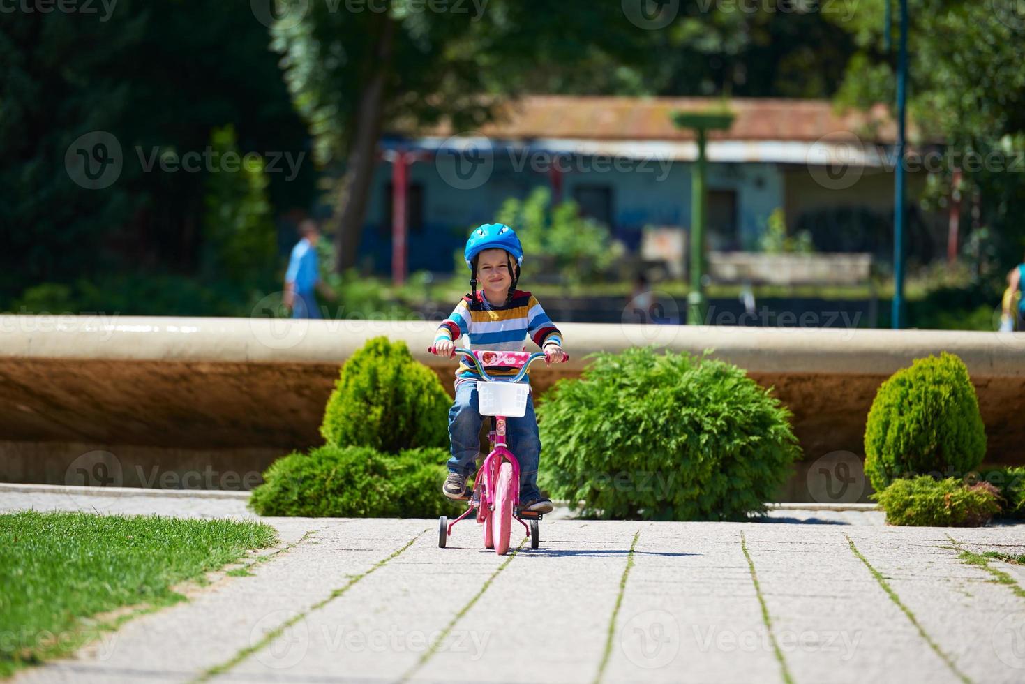 happy boy learning to ride his first bike photo