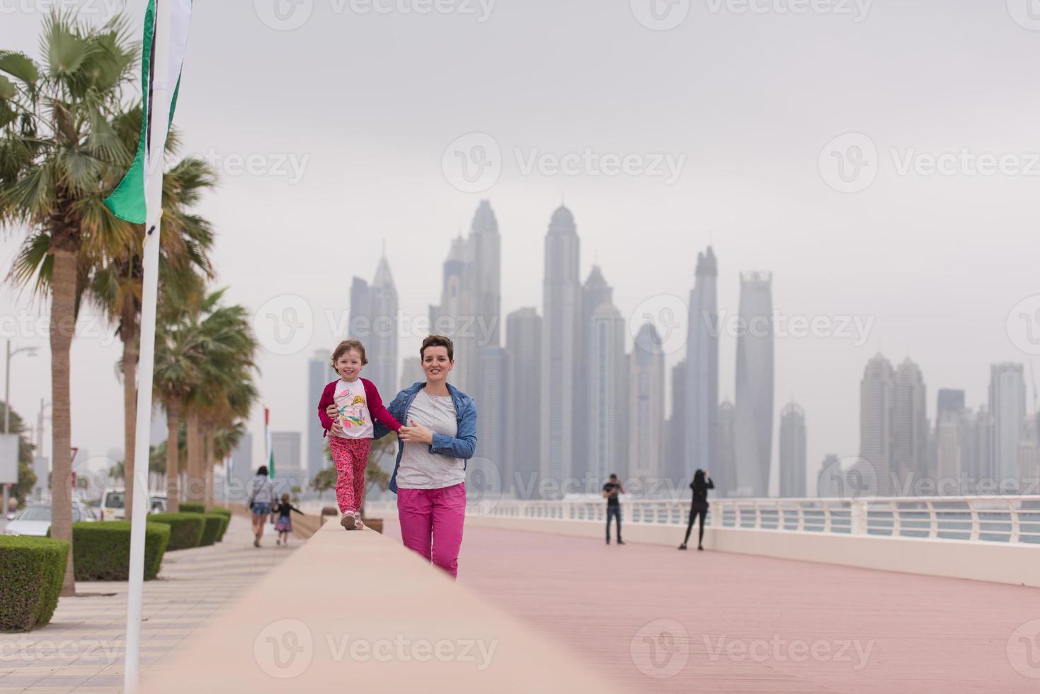 madre y niña linda en el paseo marítimo foto