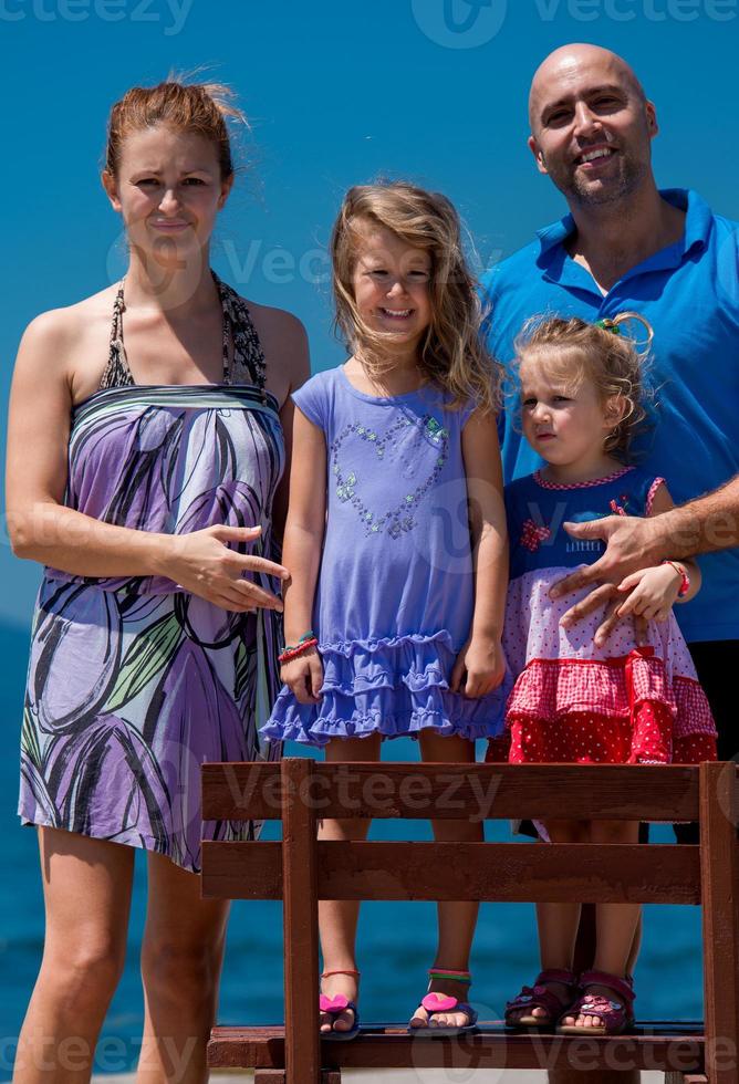 portrait of young happy family with daughters by the sea photo