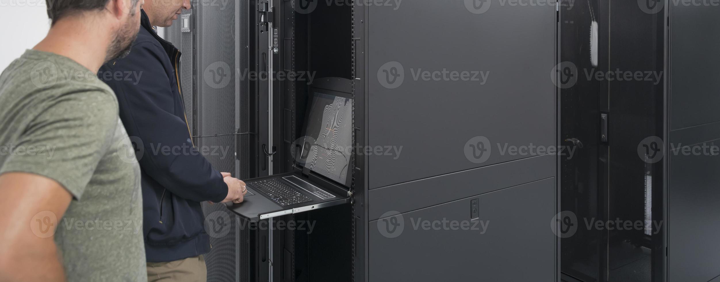Technicians team updating hardware inspecting system performance in super computer server room or cryptocurrency mining farm. photo