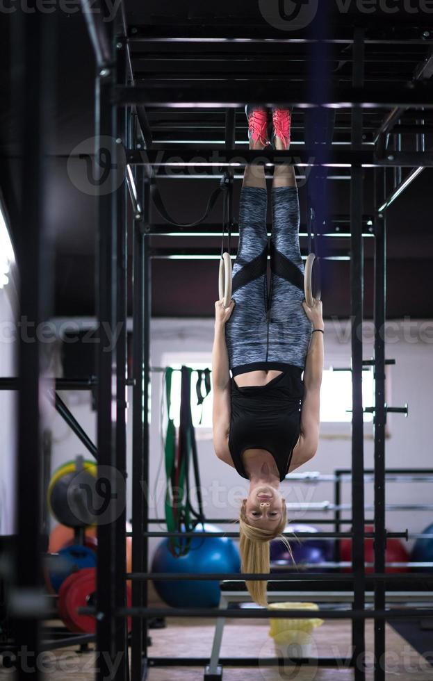 mujer trabajando en anillos de gimnasia foto