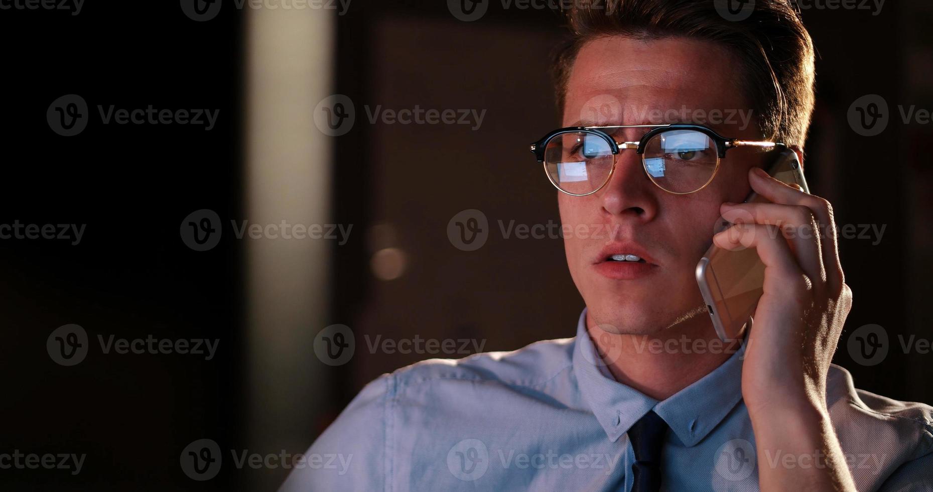 man using mobile phone in dark office photo