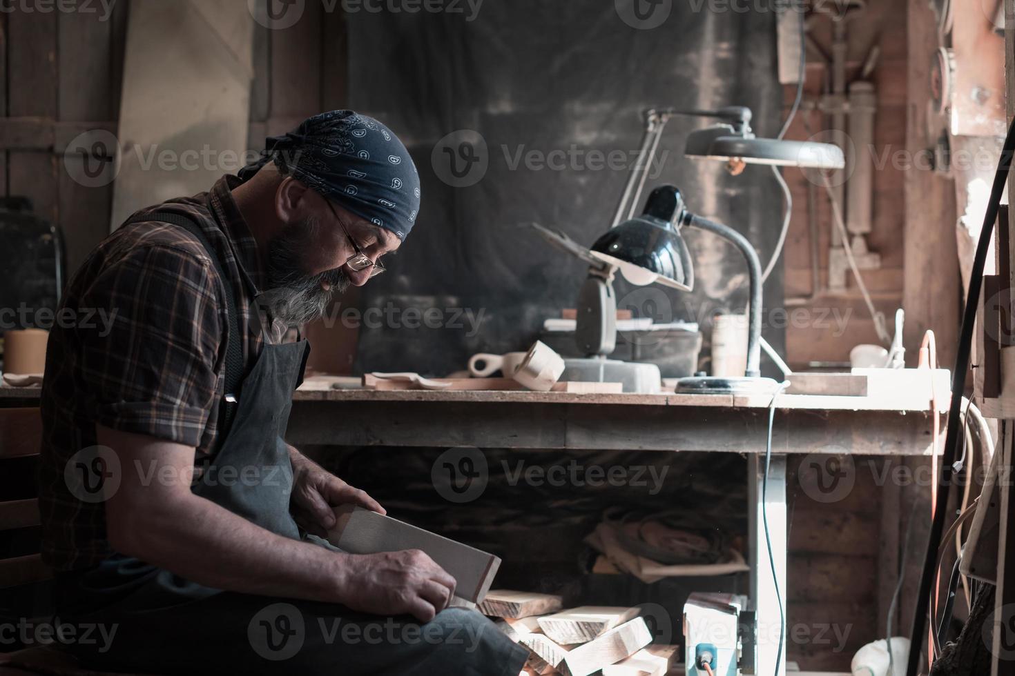 Spoon master in his workshop with wooden products and tools photo