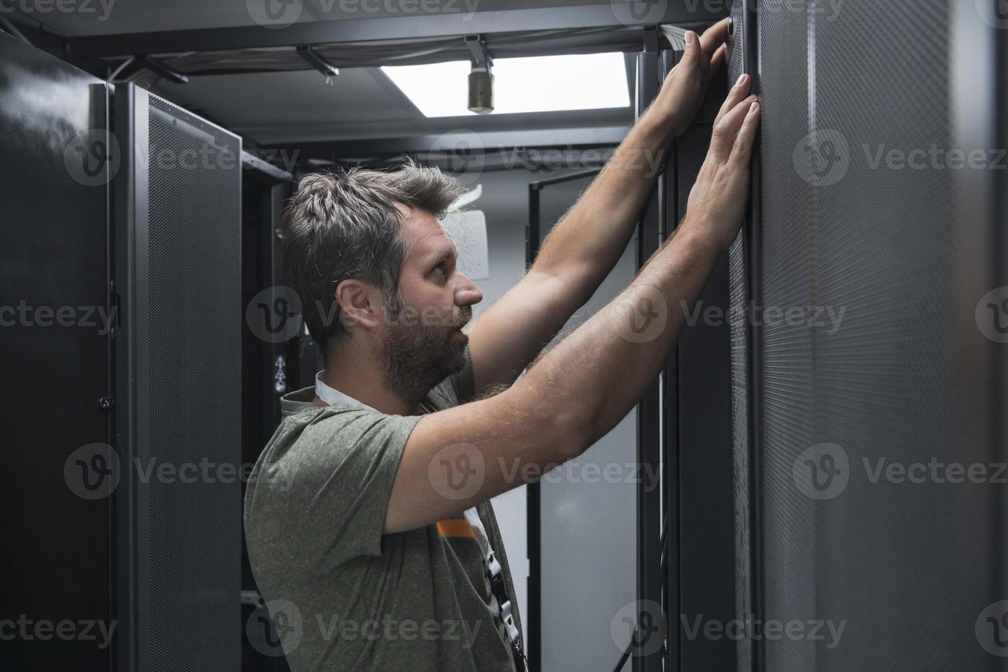 IT engineer working In the server room or data center The technician puts in a rack a new server of corporate business mainframe supercomputer or cryptocurrency mining farm. photo