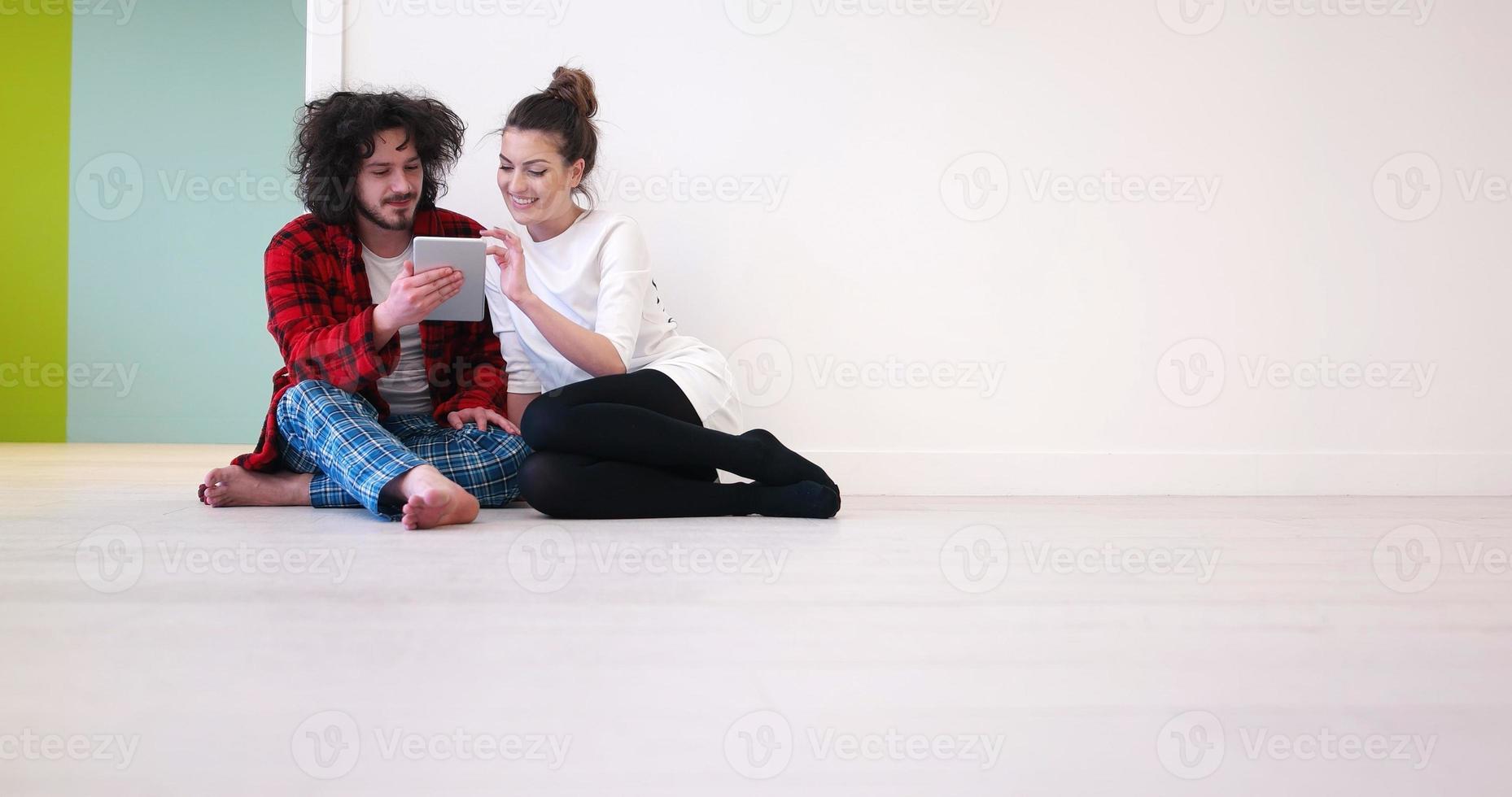 Young Couple using digital tablet on the floor photo